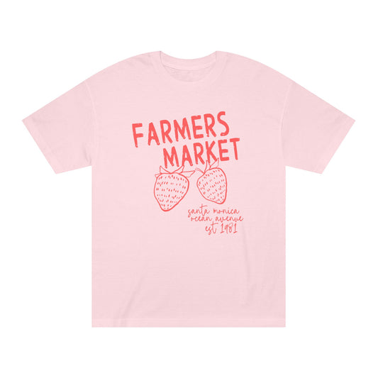 Blush pink Farmers Market graphic t-shirt featuring coral lettering and strawberry illustration inspired by Santa Monica Ocean Avenue.